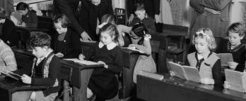 Black and white photo, school children in class