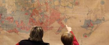 People looking at a wall-hanging map