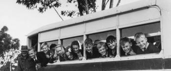 Black and white photo of kids on a school bus