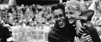 A black and white photo of two women hugging at the 1956 Olympic games