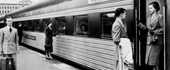 Old black and white image of man farewelling woman at train